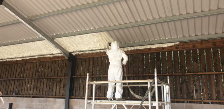 Spray foam insulation applied in an agricultural building